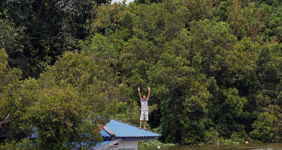 A man signals for help in Ayutthaya (Chaiwat Subprasom / Reuters)
